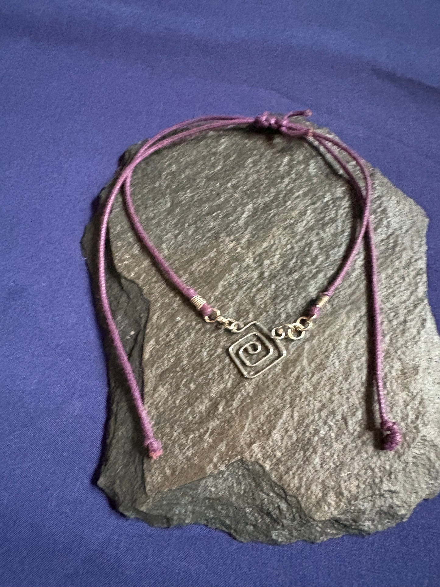 Sterling silver hand shaped pendant on purple extendable leather cord necklace.