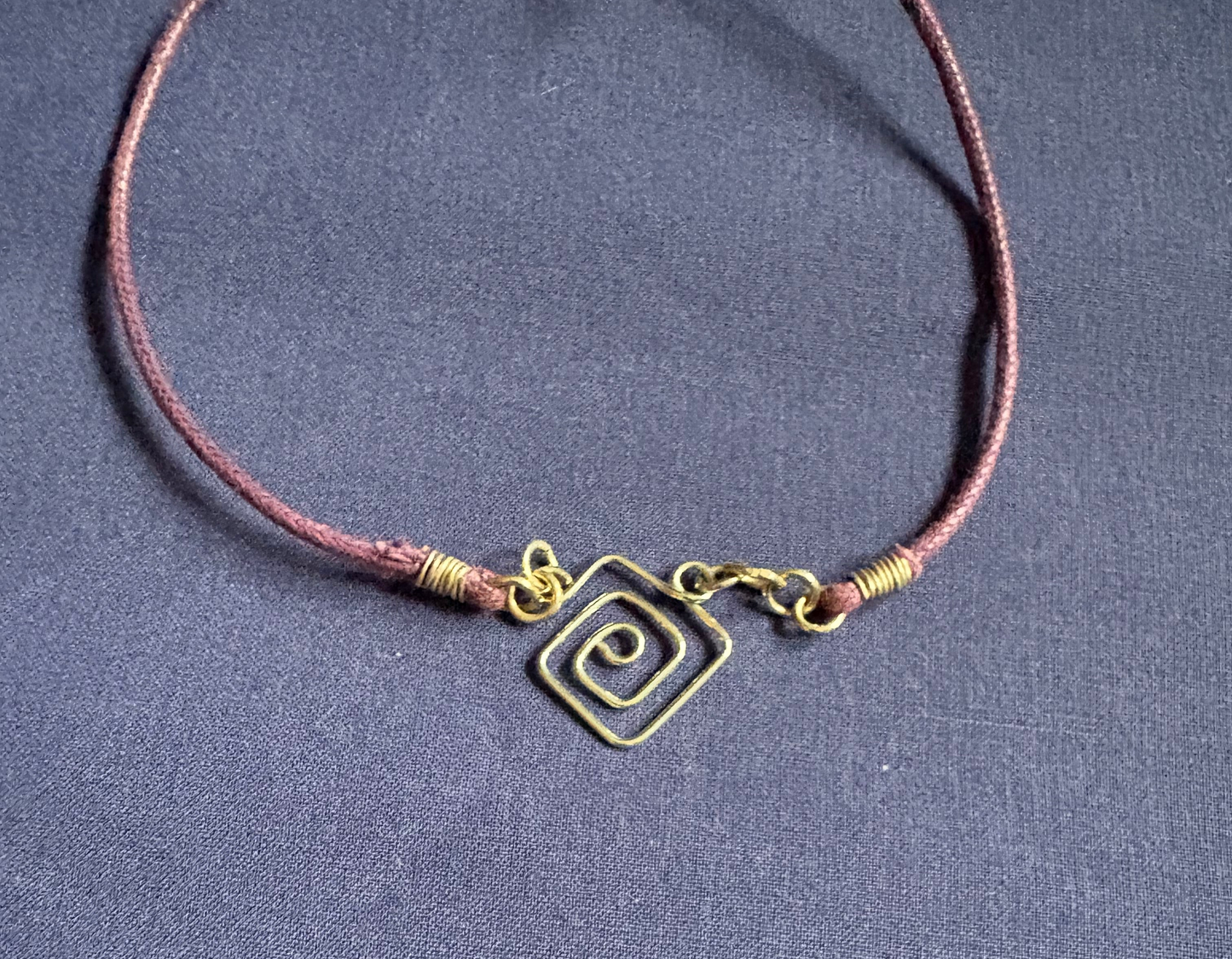 Sterling silver hand shaped pendant on purple extendable leather cord necklace.